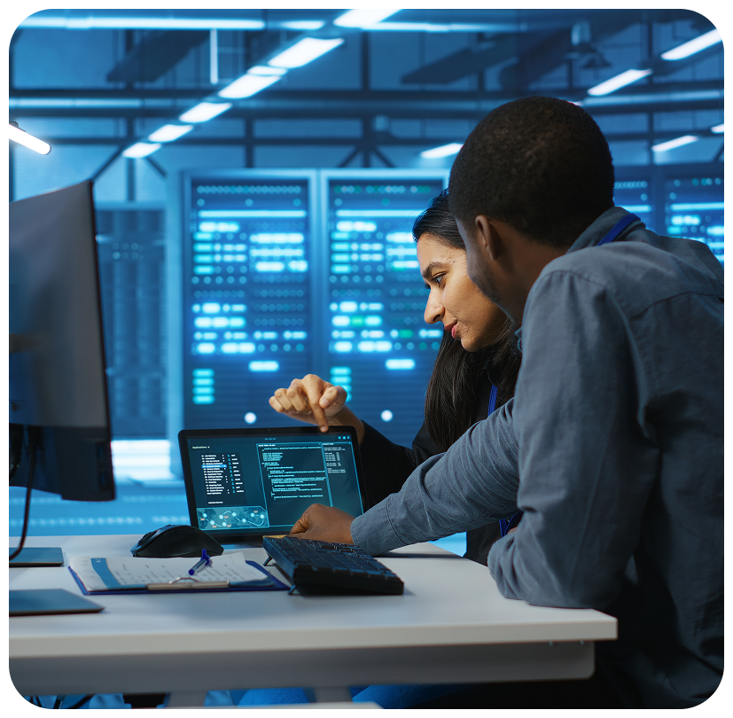 Two IT professionals reviewing code on laptop